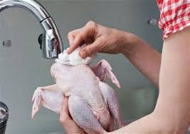 العلم يكشف سبب منع غسل الدجاج قبل الطهي